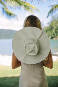 a woman in a white hat is looking at the water at Elysian Luxury Eco Island Retreat in Long Island