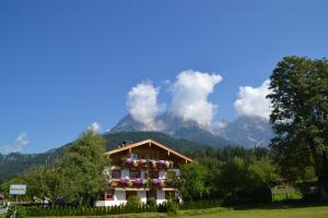 a house with flowers in front of a mountain at Ramseiderhof in Saalfelden am Steinernen Meer