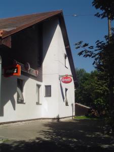 un bâtiment blanc avec un panneau sur son côté dans l'établissement Pension Baron, à Vrchlabí