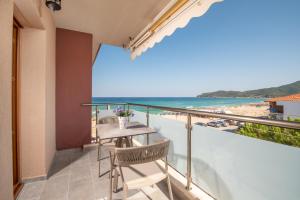 balkon ze stołem i krzesłami oraz widokiem na plażę w obiekcie Stavros Compass w mieście Sarti
