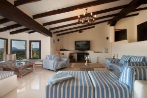 a living room with blue striped couches and a fireplace at SundanceMallorca in Port de Pollensa