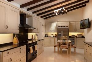 a kitchen with white cabinets and a table in it at SundanceMallorca in Port de Pollensa