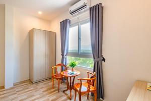 Habitación con mesa, sillas y ventana en Thoi Binh Hotel, en Cam Lâm
