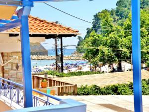 a view of the beach from a resort with blue columns at Studios Elina in Skala Potamias