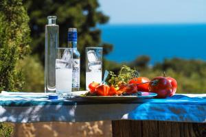 una mesa con un plato de tomates y una botella de agua en Bohemian Blue, en Hersonissos