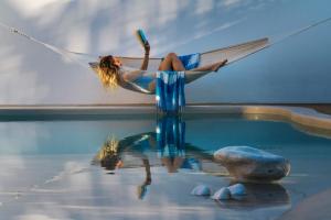 una mujer tendida en una hamaca sobre una piscina de agua en Bohemian Blue, en Hersonissos