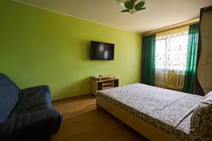 a bedroom with a bed and a tv on the wall at Babylon Apartments On Kievskaya Street in Rivne