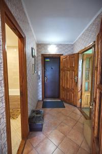a hallway with a black door and a tile floor at Babylon Apartments On Kievskaya Street in Rivne