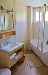 y baño con lavabo, bañera y espejo. en Suite familiale de charme en Provence en Mirabeau