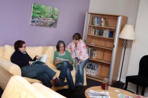 Alnwick Youth Hostel في ألنويك: ثلاث نساء جالسات على أريكة في غرفة المعيشة