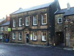 an old brick building on the side of a street at Alnwick Youth Hostel in Alnwick