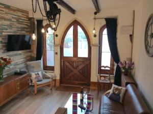 a living room with a couch and a wooden door at The Hideaway - a charming, unique retreat in Long Ashton, Bristol in Bristol