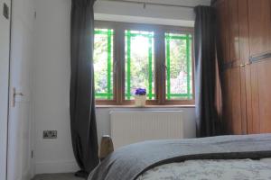 um quarto com uma cama e duas janelas em The Hideaway - a charming, unique retreat in Long Ashton, Bristol em Bristol