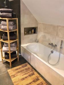 ein Badezimmer mit einer Badewanne und einem Haufen Handtücher in der Unterkunft Ferienwohnung Hünzingen in Walsrode