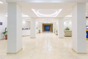 Duży, biały pokój z białymi kolumnami i korytarzem w obiekcie Kolkhida Resort & Spa w mieście Ureki
