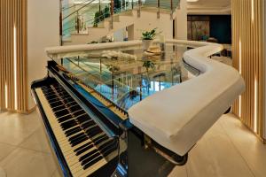 a glass table and a piano in a room at MiRaBelle Hotel - Half Board Plus & All Inclusive in Golden Sands