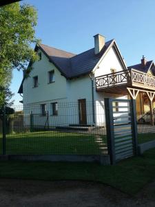 a white house with a gate and a fence at Dom na Kaszubach in Kościerzyna