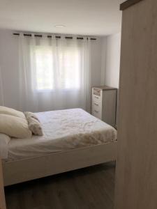a white bedroom with a bed and a window at Sun & Beach Pobla in Puebla de Farnals