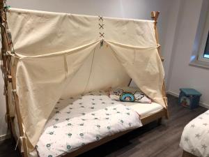 ein kleines Bett mit Baldachin in einem Zimmer in der Unterkunft Ferienwohnung Hünzingen in Walsrode