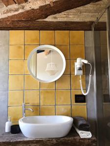 ein Badezimmer mit einem Spiegel und einem Waschbecken in der Unterkunft La Trave in Montecosaro