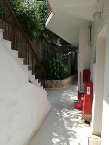 an empty hallway with stairs and plants in a building at Mario Rooms in Vasiliki