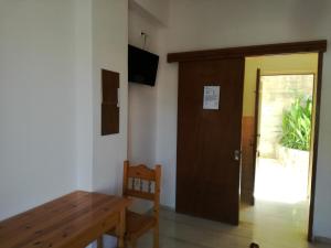 a room with a wooden door and a wooden table at Mario Rooms in Vasiliki