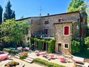 un edificio de piedra con mesas y sillas delante de él en Agriturismo Antica Dimora Del Turco, en Sona