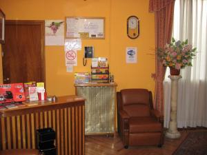 una sala de espera con una silla y una caja registradora en Hostal La Selecta, en Madrid