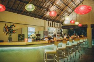 a restaurant with a bar with chairs and lights at Hibiscus Garden Inn in Puerto Princesa City