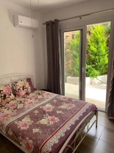 a bedroom with a bed and a large window at TASSOS-Haus in Archangelos