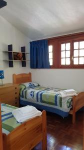 two beds in a room with blue curtains at Casa Lalla natura e relax in Cusano Mutri