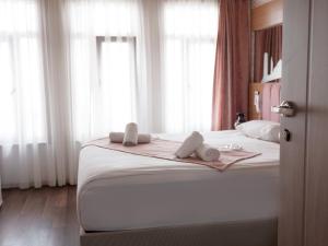 een slaapkamer met een bed met handdoeken erop bij Hotel Megaron in Istanbul
