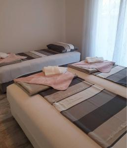 un grupo de tres camas en una habitación en Apartments Merin, en Utjeha