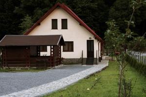 una casa bianca con tetto rosso di Gold House a Zărneşti