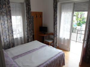 a bedroom with a bed and a sliding glass door at Hotel Rialto in Riva del Garda