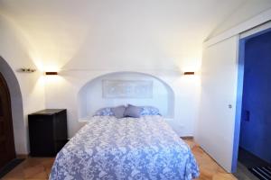 a bedroom with a bed with a blue comforter at DAMMUSI IL CARRUBO in Pantelleria