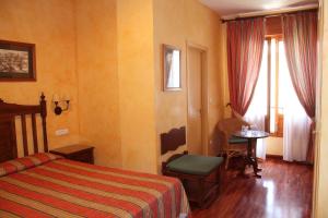 Habitación de hotel con cama, mesa y ventana en Balneario de Alhama de Granada, en Alhama de Granada