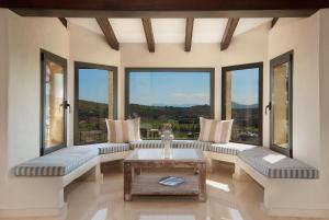 a living room with couches and a table and windows at SundanceMallorca in Port de Pollensa