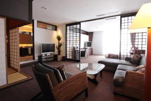 a living room with a couch and a tv at Kizashi The Suite 京都祇園 in Kyoto