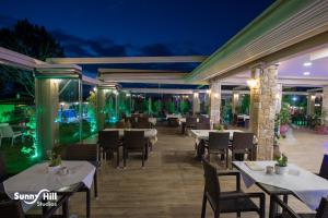 a restaurant with tables and chairs at night at Sunny Hill in Sani Beach