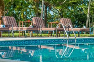 three chairs sitting next to a swimming pool at Amazing ocean views with many extras perks to enjoy in Cabarete