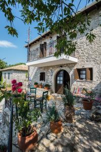 Casa de piedra con balcón y macetas en Villa Livas, en Kávallos