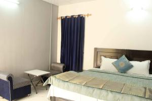a bedroom with a bed and a chair and a table at Comfort Point Bed & Breakfast in New Delhi