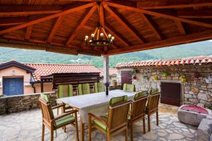 a dining table and chairs on a patio at Holiday Homes Mirjana in Mošćenička Draga
