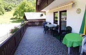 a patio with a table and chairs on a balcony at Apartments Štros in Bohinj