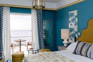a bedroom with a bed and a view of the beach at The Albatroz Hotel in Cascais