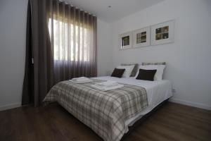um quarto com uma cama com um cobertor e uma janela em Ternaldo Agroturismo & Relax em Arco de Baúlhe