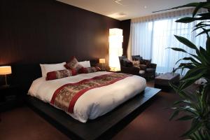 a bedroom with a large bed and a chair at Kizashi The Suite 京都祇園 in Kyoto