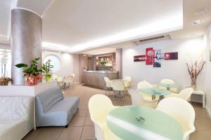 een woonkamer met tafels en stoelen en een bank bij Hotel Cuba in Milano Marittima +54 foto's