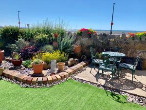 a garden with a table and chairs and plants at HomeStay In The Bay By The Beach in Heysham